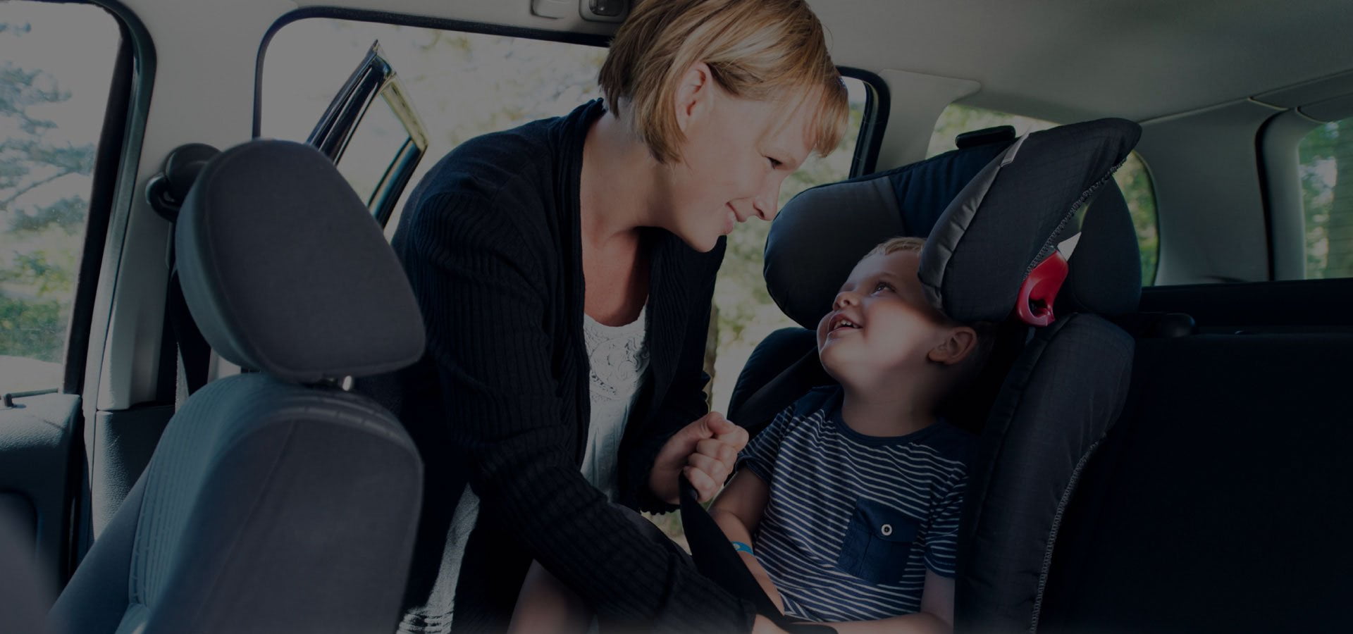 Woman putting baby into carseat